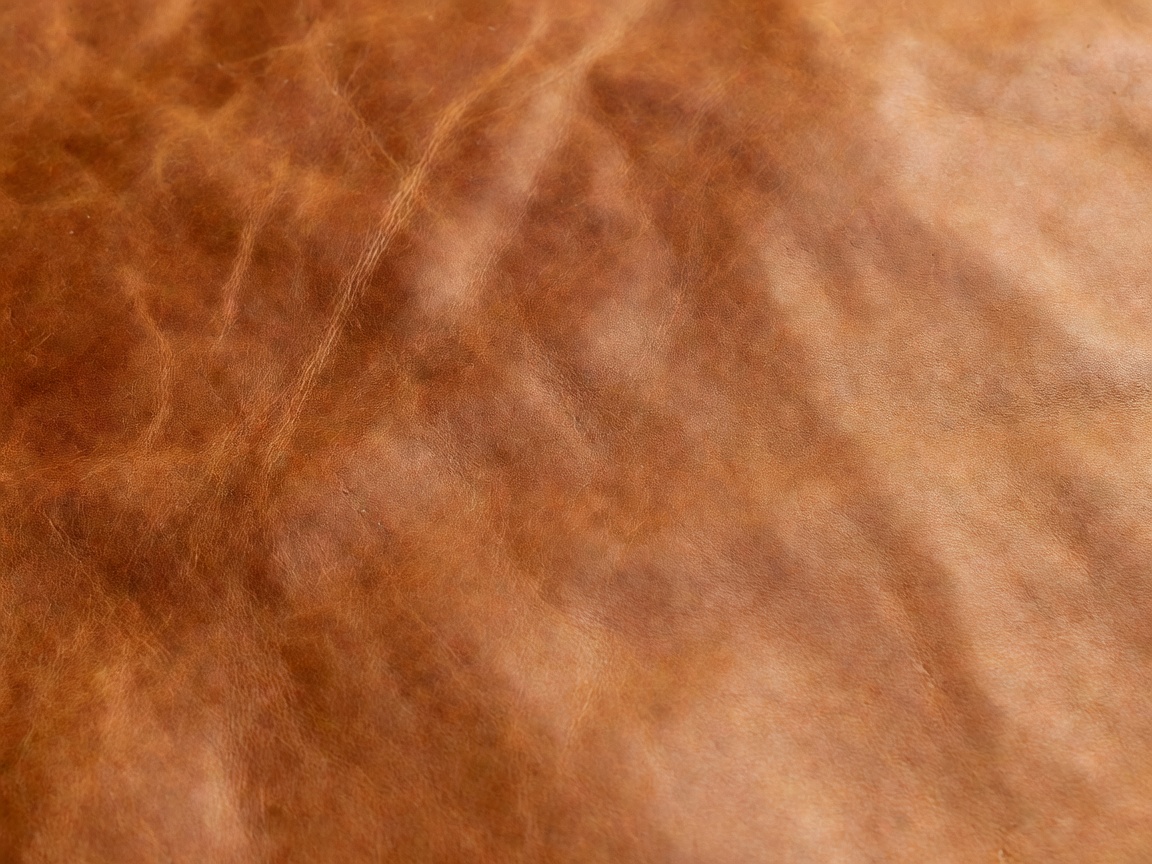 Warm vegetable-tanned leather hide showing natural grain and colour variation